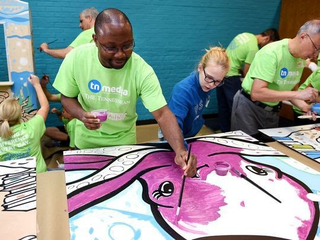 Tennessean reporter Getahn Ward, left, and Olivia Cass, daughter of TN Media Marketing Manager Heather Cass, paint an octopus for a children’s mural during Make A Difference Day on Oct. 24, 2015. (Shelley Mays/Tennessean)